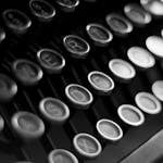 Close-up shot of vintage typewriter keys in black and white, highlighting classic technology.